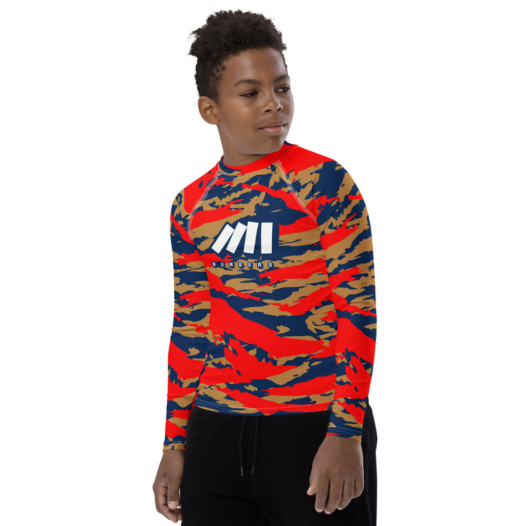 Athletic sports compression shirt for youth football, basketball, baseball, golf, softball etc similar to Nike, Under Armour, Adidas, Sleefs, printed with camouflage navy blue, gold, and red colors.  